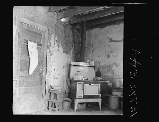 Kitchen with stove bought last winter from Denver salesman. Great Western Sugar Company's beet sugar workers colony at Hudson, Colorado. The housewife says, "The man told me it would save its cost in food, but the roof leaks so bad it's getting all rusted up" (Notice hole in adobe wall above stove; 