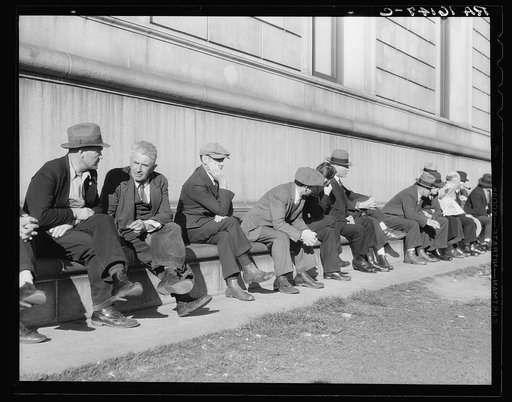 Unemployed men sitting on the sunny side of the San Francisco Public Library. California