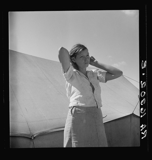 Woman in pea picker's camp. California. "I seen our corn dry up and blow over the fence back there in Oklahoma"