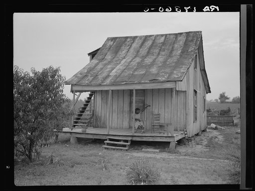 Cotton field hand sitting on her porch on Sunday afternoon. Near Blytheville, Arkansas