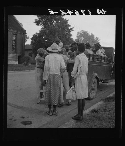 Cotton hoers leaving Greenville at 5 a.m. for a day's work on the plantations. Wages one dollar a day, one dollar and twenty-five cents on a few plantations. Hoers carry their lunches. They return about 8 p.m. Mississippi