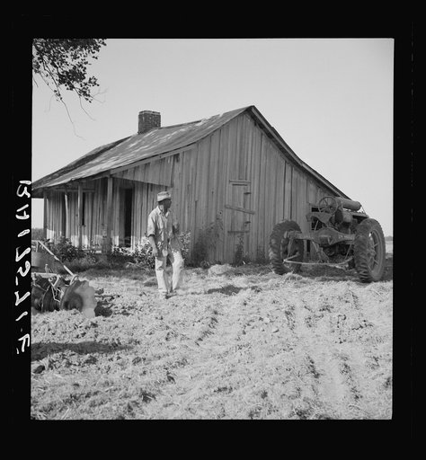 Colored tractor driver and empty cabin on mechanized cotton plantation.  Aldridge Plantation near Leland, Mississippi