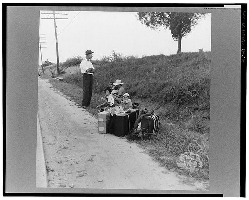 A hitchhiking family waiting along the highway in Macon, Georgia. The father repairs sewing machines, lawn mowers, etc. He is leaving Macon, where a license is required for such work (twenty-five dollars) and heading back for Alabama