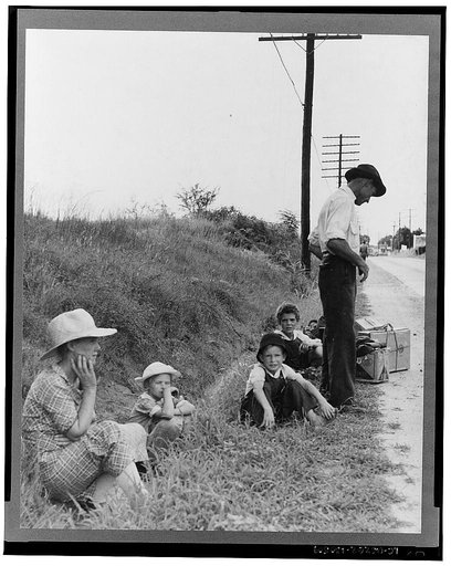 A hitchhiking family waiting along the highway in Macon, Georgia. The father repairs sewing machines, lawn mowers, etc. He is leaving Macon, where a license is required for such work (twenty-five dollars) and heading back for Alabama