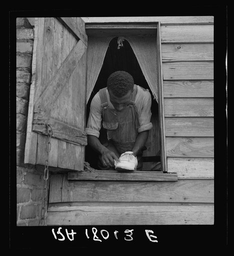 Negro field hand getting ready to go to town on a Saturday afternoon. His wages seventy-five cents a day and cabin. He has six children