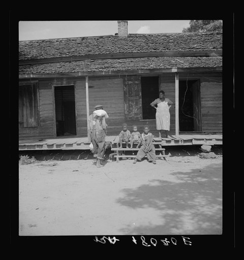 Negro wage laborer and part of his family. He is coming home from the commissary with a week's rations. Macon County, Georgia