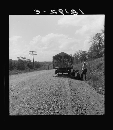 On highway no. 1 of the "OK" state near Webbers Falls, Muskogee County, Oklahoma. Seven children and eldest son's family. Father was a blacksmith in Paris, Arkansas. Son was a tenant farmer. "We're bound for Kingfisher (Oklahoma wheat) and Lubbock (Texas cotton). We're not trying to but we'll be in 