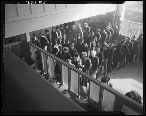 Unemployment benefits aid begins. Line of men inside a division office of the State Employment Service office at San Francisco, California, waiting to register for benefits on one of the first days the office was open. They will receive from six to fifteen dollars per week for up to sixteen weeks. C