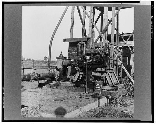 This pumping plant for irrigation is powered by a natural gas engine which operates on cost of about 1/2 the cost of electricity, Tulare County, California. Butane (natural gas in tanks) as a source of power on small farms is being developed by the Farm Security Administration Rural Rehabilitation P