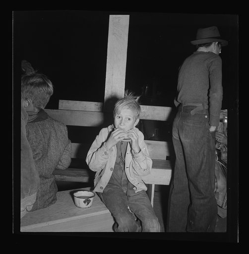 Hungry boy at the Halloween party for migrant workers. Shafter migrant camp, California