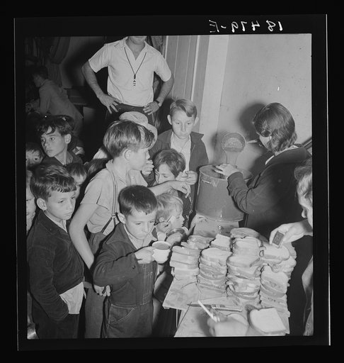 The children crowd and push to reach the refreshments at Halloween party in Shafter migrant cooperative. California