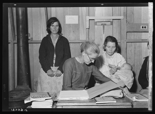 Meeting of the Mothers' Club in Arvin camp for migrant workers, a Farm Security Administration (FSA) camp. The discussion this evening centers on the possibility of buying kerosene oil in large quantities and distributing it cooperatively in camp, to cut costs. Kerosene is used both for cooking and 