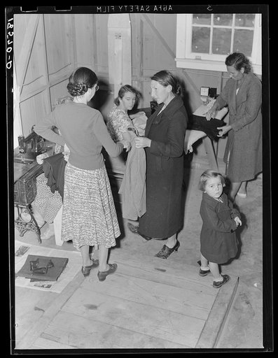 Camper receives help in fitting a coat from Works Progress Administration (WPA) sewing instructor. Shafter camp for migratory agricultural workers (Farm Security Administration-FSA), California