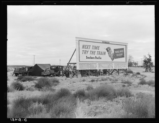 Untitled photo, possibly related to: Billboard along U.S. 99 behind which three destitute families of migrants are camped. Kern County, California