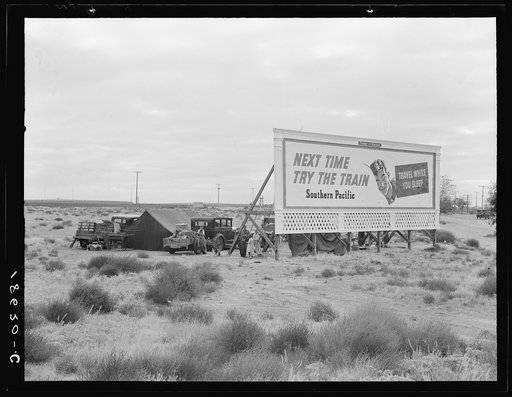Untitled photo, possibly related to: Billboard along U.S. 99 behind which three destitute families of migrants are camped. Kern County, California