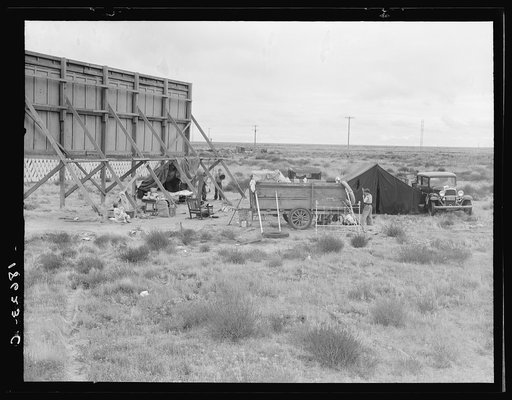 Untitled photo, possibly related to: Billboard along U.S. 99 behind which three destitute families of migrants are camped. Kern County, California