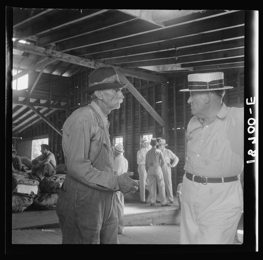 Each farmer follows his tobacco in the warehouse to learn what price it brings at auction. Douglas, Georgia