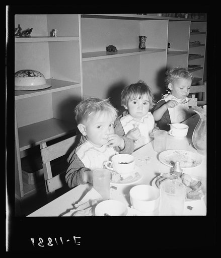 Lunchtime for young migrants at Shafter Camp, California. The nursery school for migrant children is conducted in camp under nursery school teachers trained by WPA (Work Projects Administration), and assigned to work in the camp under (WPA) project