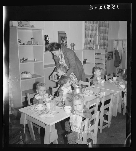 Lunchtime for young migrants at Shafter Camp, California. The nursery school for migrant children is conducted in camp under nursery school teachers trained by WPA (Work Projects Administration), and assigned to work in the camp under WPA project