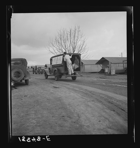 United States government camp for migrants (Farm Security Administration), Farmersville, California. Prefabricated steel dwellings "one step up from a tent" replace the use of tents in the newer California camps