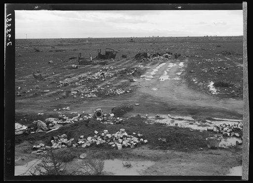 Kern County. Debris left out on the flats where squatters' camp stood during work season. These are common sights after the migrants have left