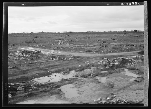 Kern County. Debris left out on the flats where squatters' camp stood during work season. These are common sights after the migrants have left