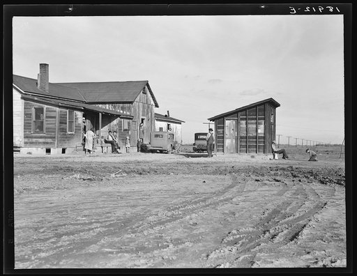 Outskirts of Firebaugh. West side of San Joaquin Valley, California. Six families with twenty-two children live in this house. Cotton workers: "He's good (the boss). He lets us live here without paying rent."