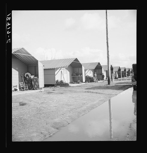 Prefabricated steel dwellings (one step up from a tent) replace the use of a tent in the newer California camps. United States government camp for migrants, Farm Security Administration. Farmersville, California