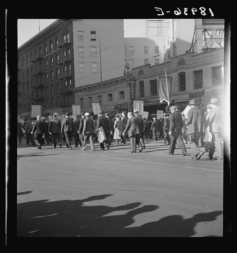Mass meeting of Works Progress Administration (WPA) workers parading up Market Street, San Francisco, California. The meeting was held in protest to cuts made by Congress in relief appropriations