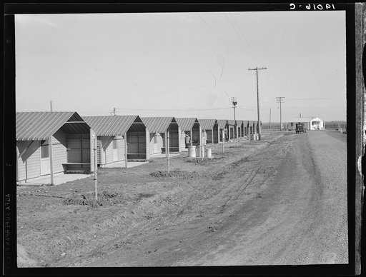 United States government camp for migratory workers, (Farm Security Administration-FSA), Westley, California. Pre-fabricated steel shelters replace the use of tents and tent platforms in this newly constructed camp. Camp manager's house at end of avenue