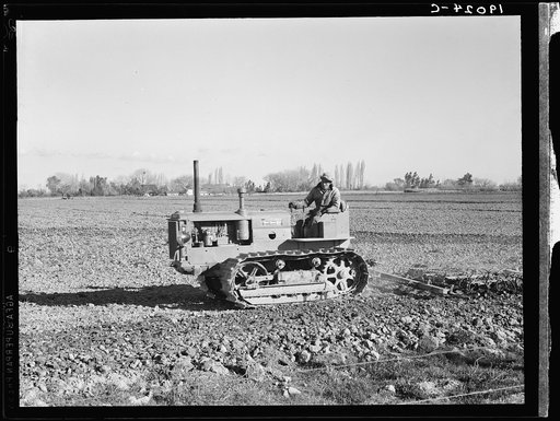 Untitled photo, possibly related to: West side of San Joaquin Valley, California. Caterpillar diesel type tractor is common in California. Only very large-scale operations can afford this type. Cultivating potato-fields