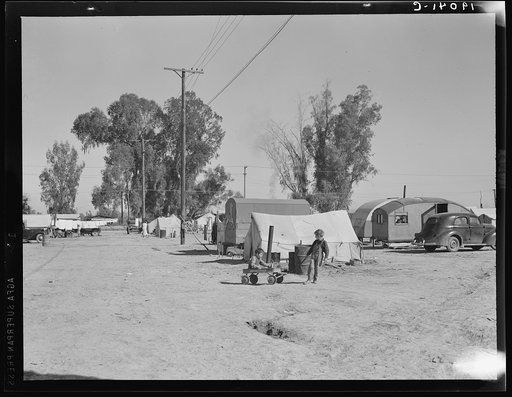 Near Holtville, Imperial Valley, California. Migratory labor housing during carrot harvest. This field owned by proprietor of adjoining grocery and general store who allows workers to camp here rent-free. Approximately sixty families were living in camp here