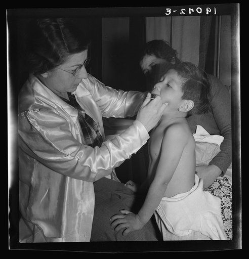Calipatria, Imperial Valley. Visiting public health doctor conducts well-baby clinic in local school building adjacent to pea harvest. Many migratory mothers attend