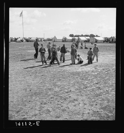 Marble time in Farm Security Administration (FSA) migratory labor camp (emergency.) Plenty of space to play and plenty of companions for the children during pea harvest. Near Calipatria, Imperial Valley, California