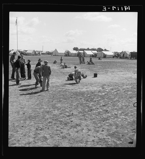 Untitled photo, possibly related to: Marble time in Farm Security Administration (FSA) migratory labor camp (emergency.) Plenty of space to play and plenty of companions for the children during pea harvest. Near Calipatria, Imperial Valley, California