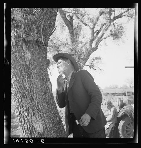 Untitled photo, possibly related to: On U.S. 99 between Bakersfield and the Ridge, en route to San Diego. Migrant man shaving by roadside. See general caption 1.
