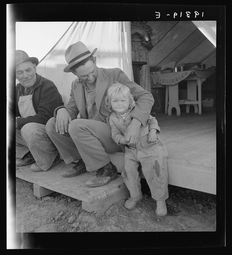 Farm Security Administration (FSA) migratory labor camp. Brawley, California. Father is home after a day in the pea fields. Note tent platform, standard equipment in Farm Security Administration camps
