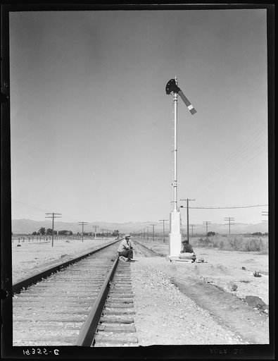 Looking east down the railroad track, near Calipatria, California. Single men, itinerants with "bindles" waiting for the freight