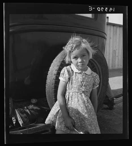 Arkansas girl in migrant camp near Greenfield, Salinas Valley, California. This is an Arkansawyers auto camp, filled almost completely with Arkansawyers recently in California. Rent ten dollars per month for one room, iron bed, electric light. (This community is subject of a study by Regional Office