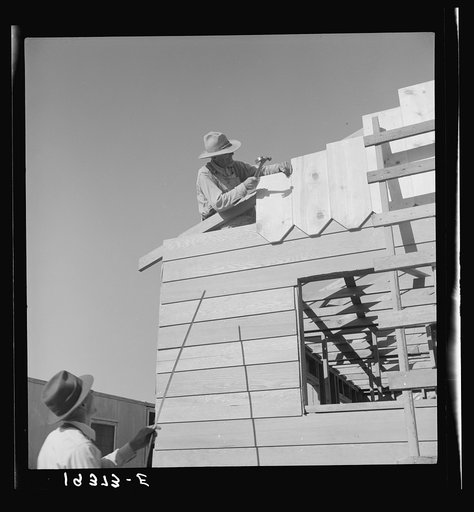 Untitled photo, possibly related to: Father and son, recent migrants to California, building house in rapidly growing settlement of lettuce workers on fringe of town. Salinas, California