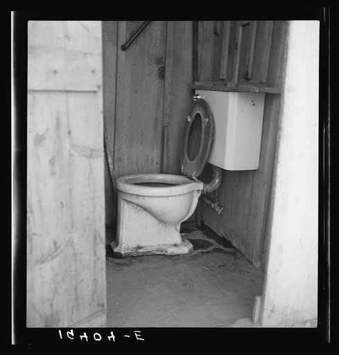 Toilet for ten cabins, men, women and children in auto camp for Arkansawyers, recent migrants to California. Rent for cabins ten dollars a month. Greenfield, Salinas Valley, California