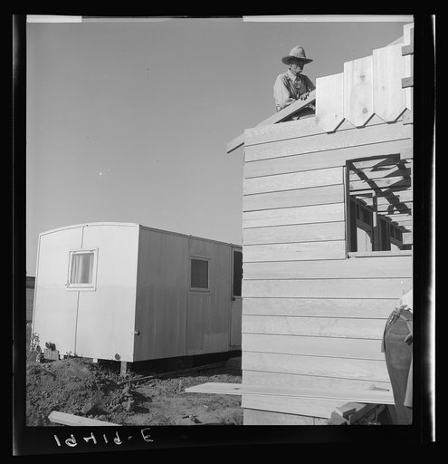 Untitled photo, possibly related to: Father and son, recent migrants to California, building house in rapidly growing settlement of lettuce workers on fringe of town. Salinas, California