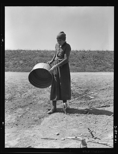 A grandmother in a migrant camp. Stanislaus County, California. "Been in California fourteen months. From Oklahoma. The main thing is to get our families located and quieted down. Ain't no use to send them back; it's a waste of money. They won't stay."