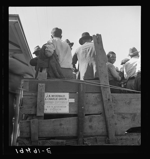 Labor contractor's truck with gang of pea pickers pulled up for gas. Gang recruited in Stockton, thirty-one miles away. Westley, California