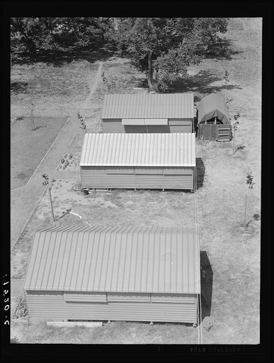 Farm Security Administration (FSA) camp for migratory agricultural workers. Farmersville, California. Shows prefabricated steel shelters which have been erected to replace tents as standard camp equipment in two of the California camps