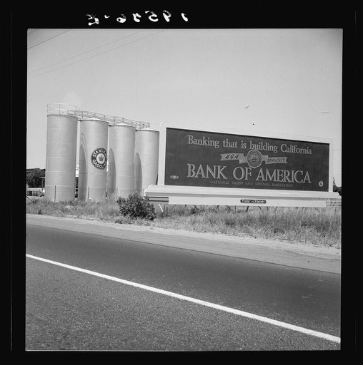 Between Tulare and Fresno on U.S. 99. Highway gas tanks and signboard approaching town. See general caption