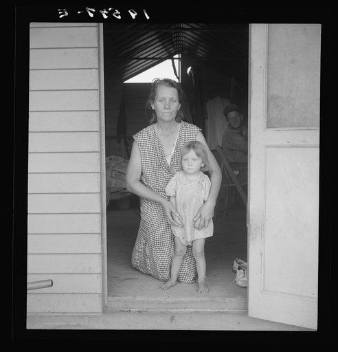 Tulare County, Farm Security Administration (FSA) camp. Migrant mother and child at doorway of steel shelter