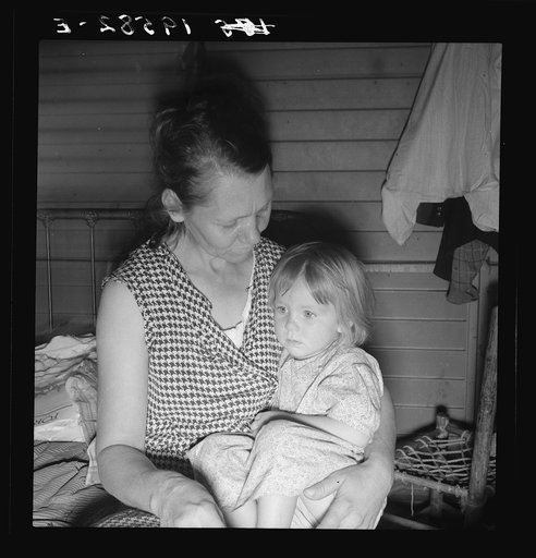 Farm Security Administration (FSA) camp at Farmersville, California. Mother from Oklahoma, migrant, awaits visit of resident nurse for sick baby