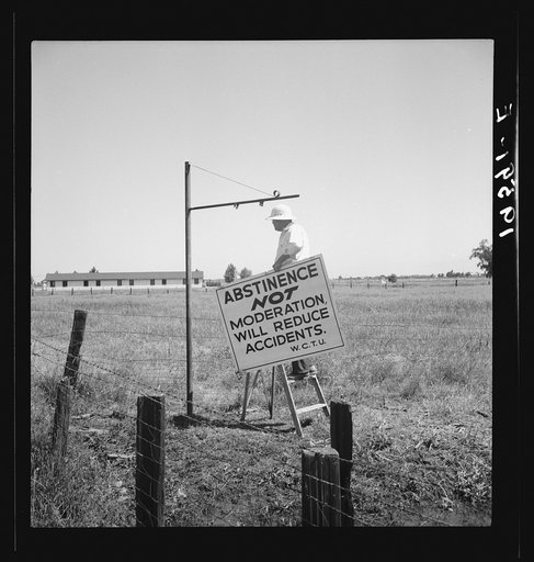 Untitled photo, possibly related to: Near Hanford, California. See general caption. On U.S. 99. A member of the committee from adjoining town erects sign on the highway