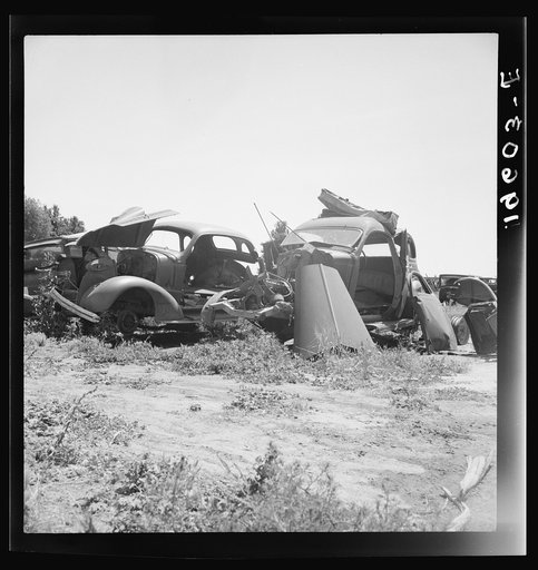 Untitled photo, possibly related to: Near Tulare, California, U.S. 99. See general caption. Used car lots and auto wrecking establishments add to the litter which fronts this highway